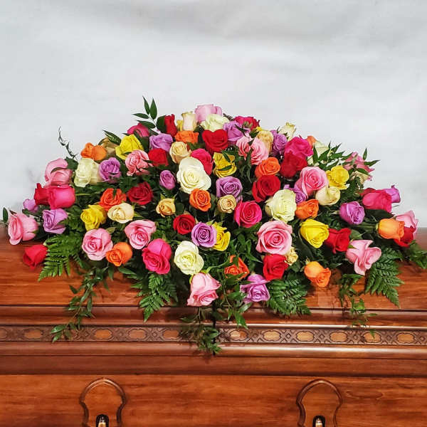 Large multicolored rose arrangement on a wooden casket