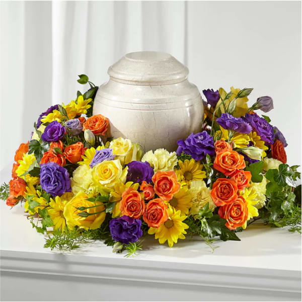 Colorful floral urn surround with roses and daisies around a cream urn