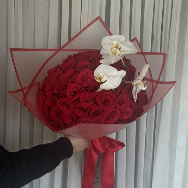 Large bouquet of red roses with white orchids wrapped in red paper