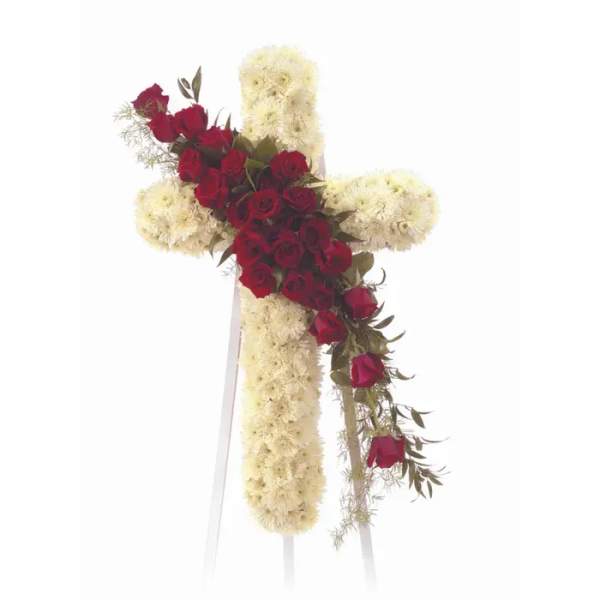 Red roses and white flowers arranged in a cross on a stand