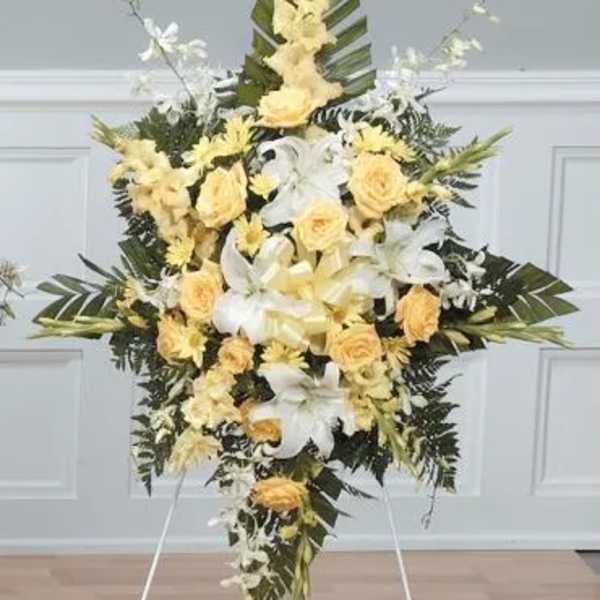 Standing floral spray with yellow roses and white lilies on an easel