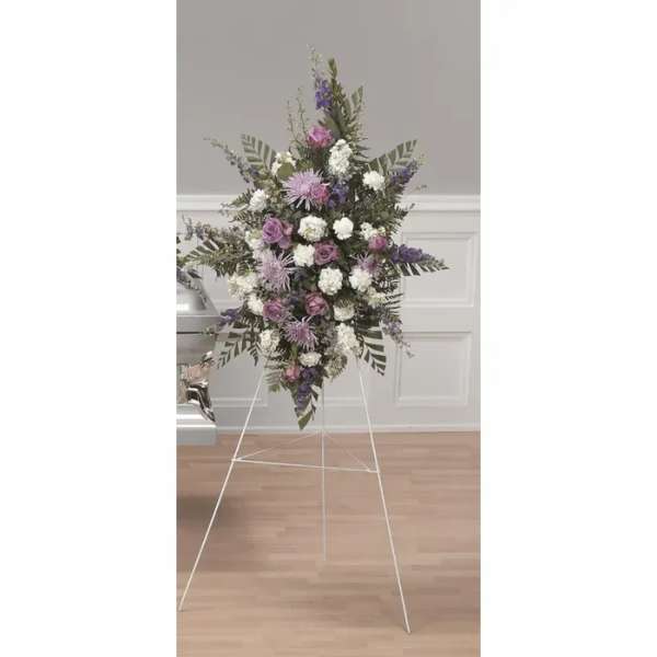 Standing floral spray with purple and white flowers on a metal easel