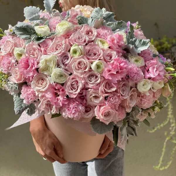 Large pink bouquet of roses and ruffled blooms in a box