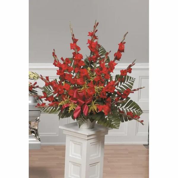 Tall red floral arrangement in a silver vase with a ribbon