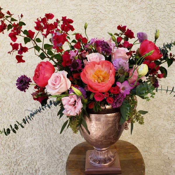 Large mixed bouquet in a metallic urn vase with pink and red blooms