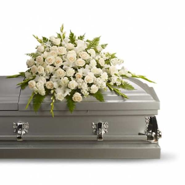 White floral casket spray on a gray casket