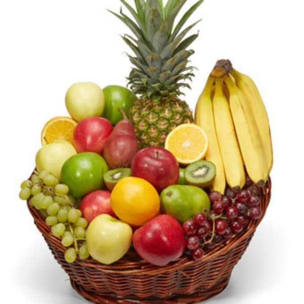 Basket of assorted fruit including bananas, pineapple, grapes, apples, and citrus