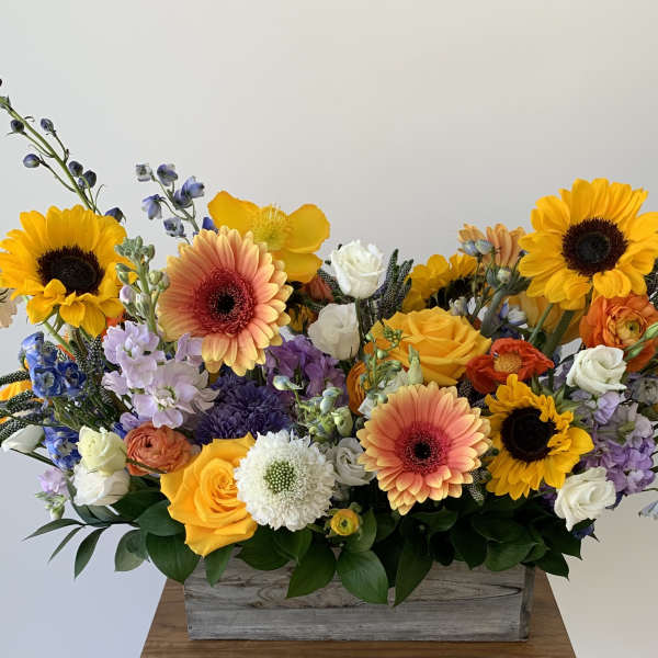 Colorful mixed flower arrangement in a wooden box
