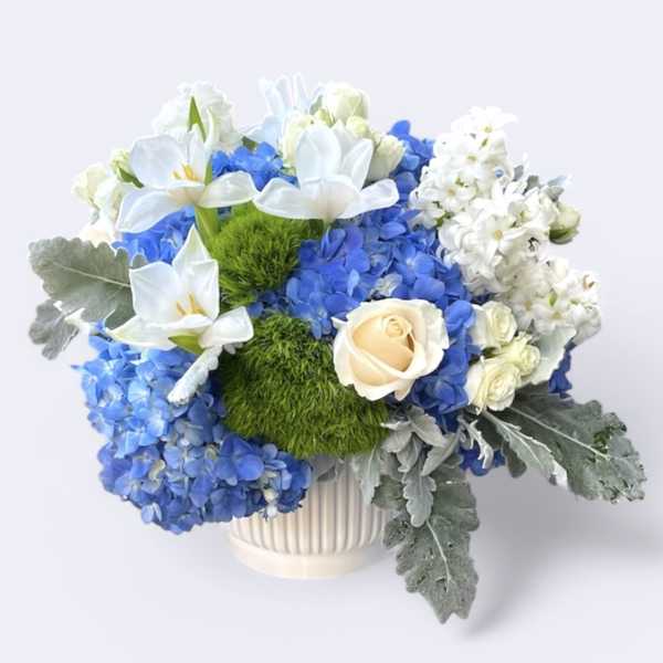 Blue and white floral arrangement in a white vase