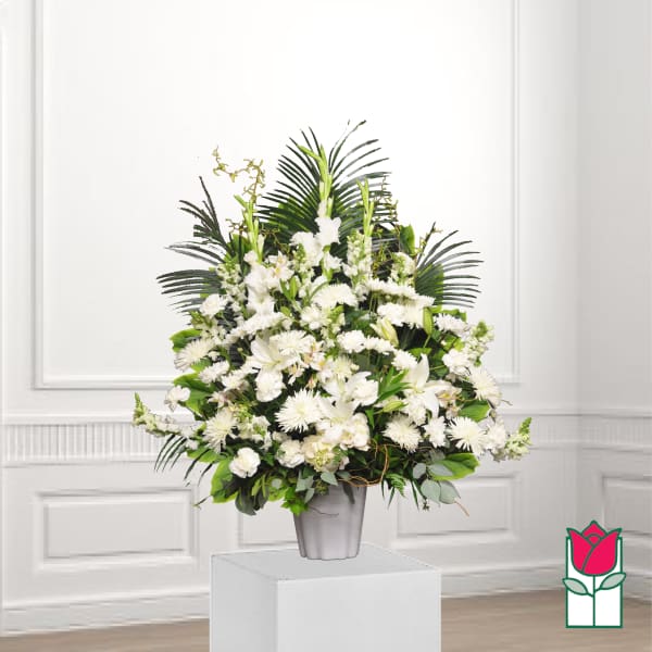 White floral arrangement in a gray vase with palm fronds