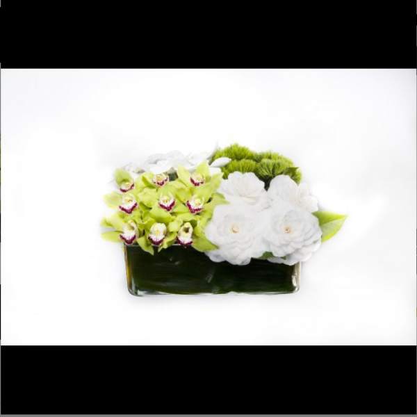 White and green floral arrangement in a rectangular glass vase