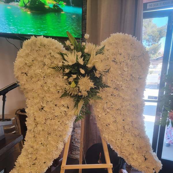 Large white floral standing spray on an easel in a wing shape