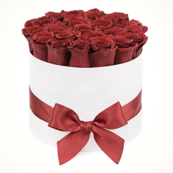 Round box of red roses with a red satin ribbon