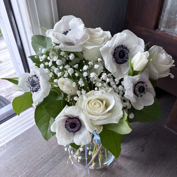 White roses and anemones in a glass vase