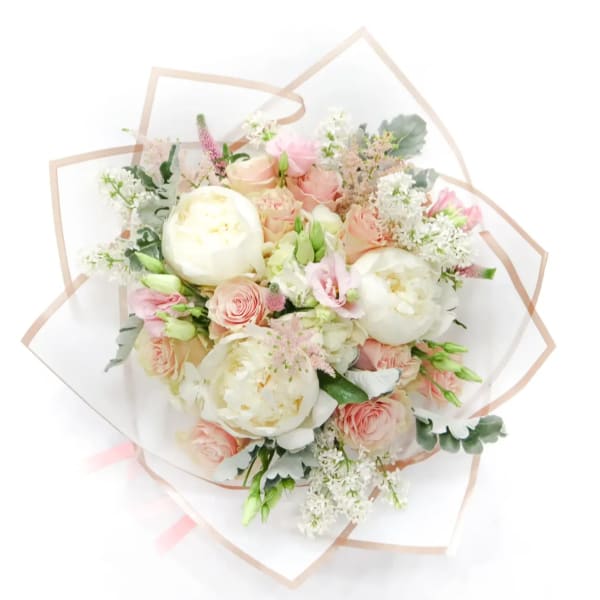 Bouquet of blush and white flowers wrapped in clear paper