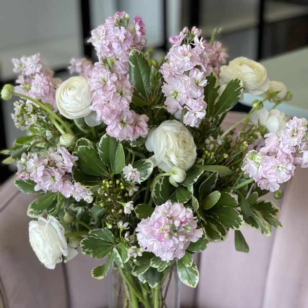 Pink stock and white ranunculus in a clear glass vase
