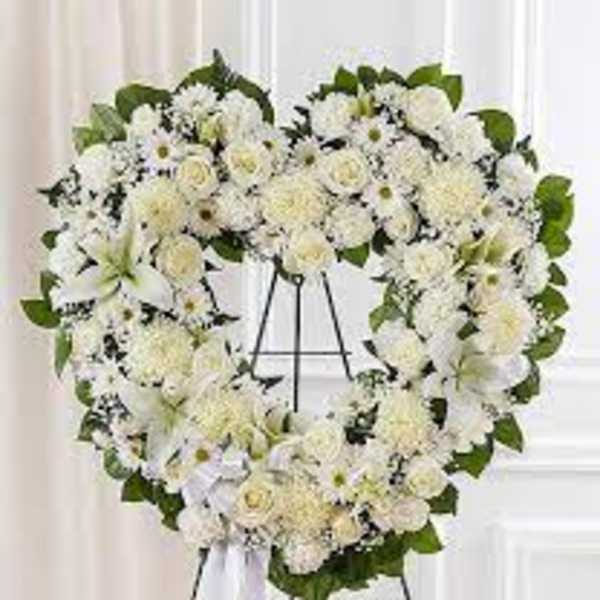 Heart-shaped white floral wreath on an easel