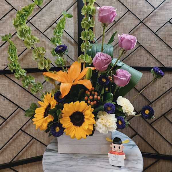 Mixed bouquet with sunflowers, pink roses, and orange lilies in a white box
