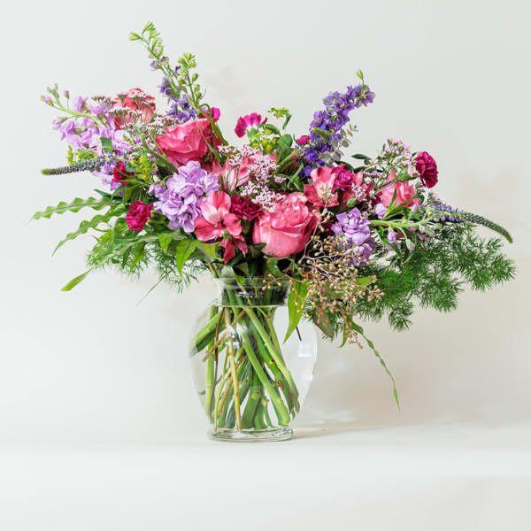 Pink and purple mixed bouquet in a clear glass vase