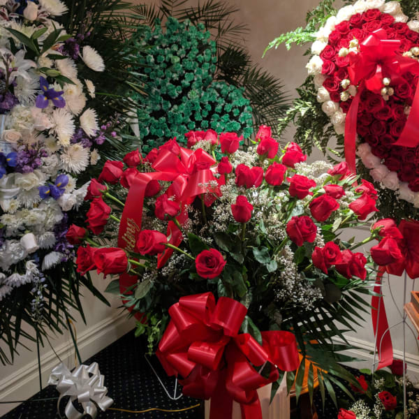Large red rose arrangement with ribbon bows in a room
