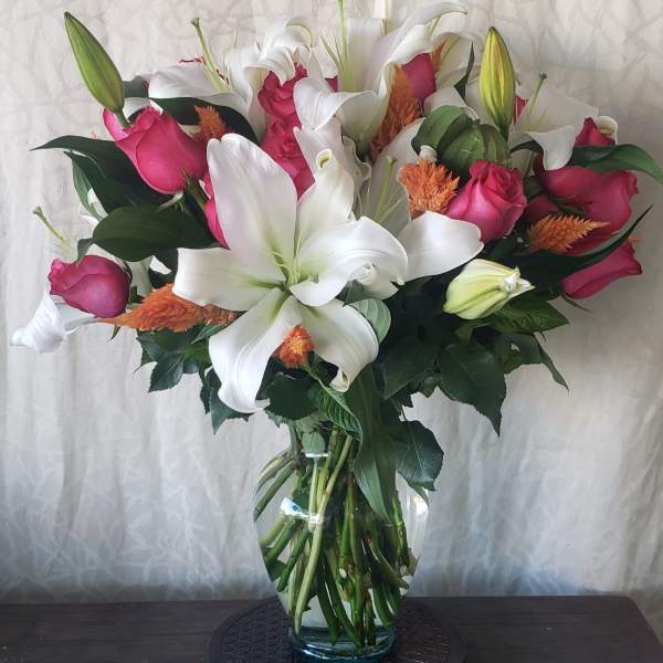 Bouquet of white lilies and pink roses in a glass vase