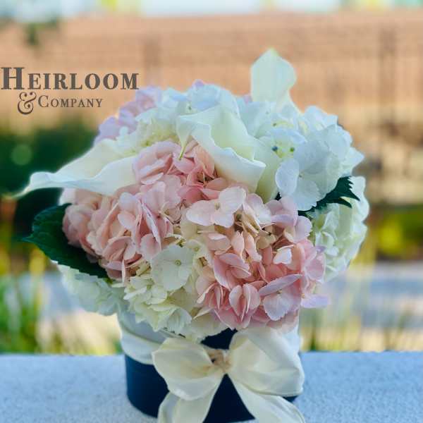 Pink and white hydrangea bouquet in a black hatbox with a white bow