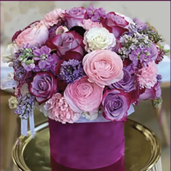 Pink and purple rose bouquet in a magenta hatbox