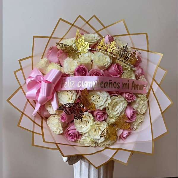 Large bouquet of pink and white roses with a pink ribbon and butterfly decorations