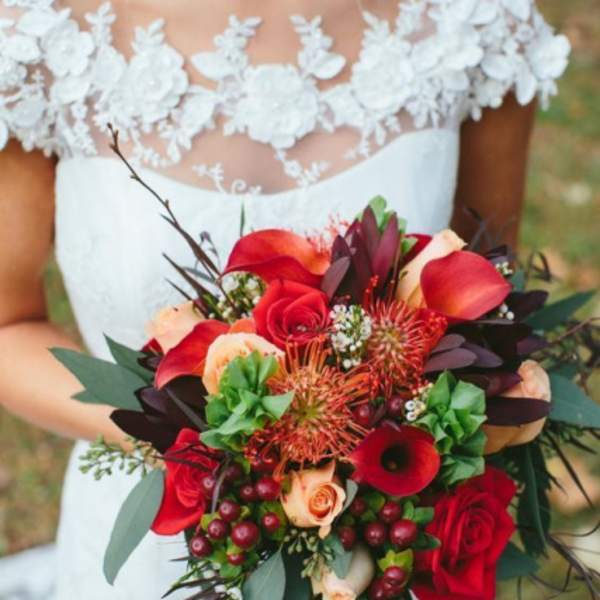 Bride holding a red and peach wedding bouquet