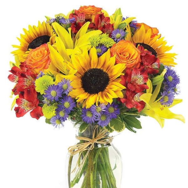 Bright mixed bouquet with sunflowers, roses, and purple daisies in a glass vase