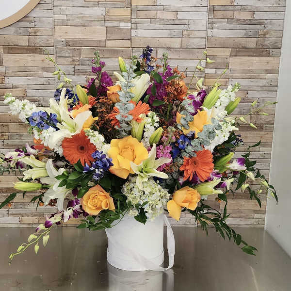 Large mixed bouquet in a white hatbox with yellow roses and lilies