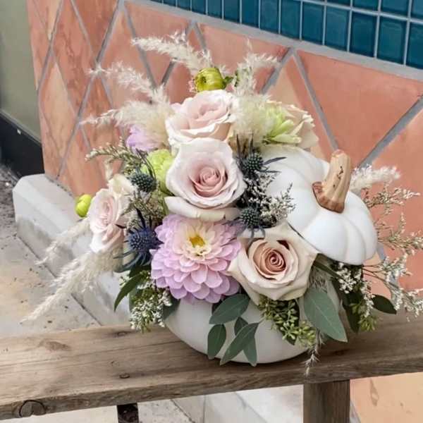 Pastel floral arrangement in a white pumpkin container