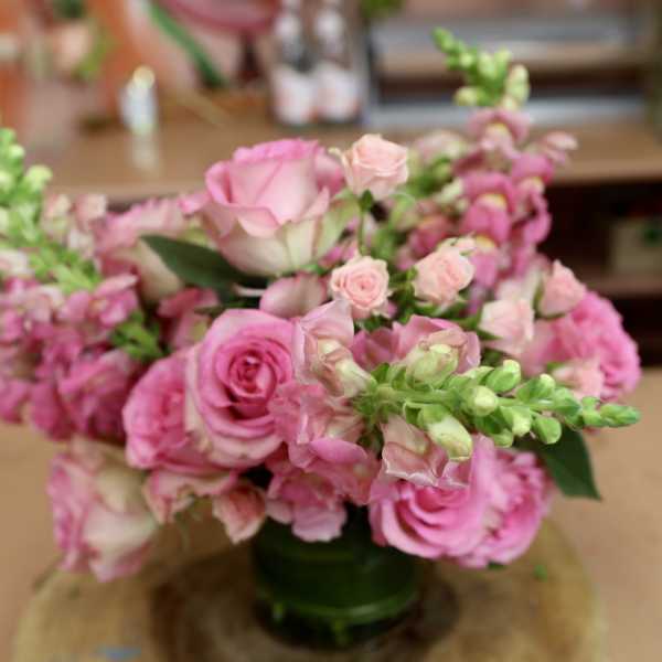 Pink roses and snapdragons arranged in a glass vase
