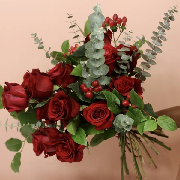 Bouquet of red roses with eucalyptus and red berries