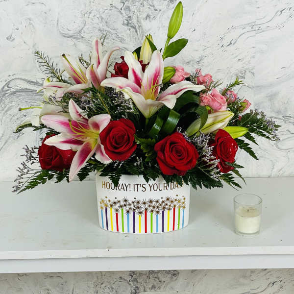 Bouquet of red roses and pink lilies in a decorative box