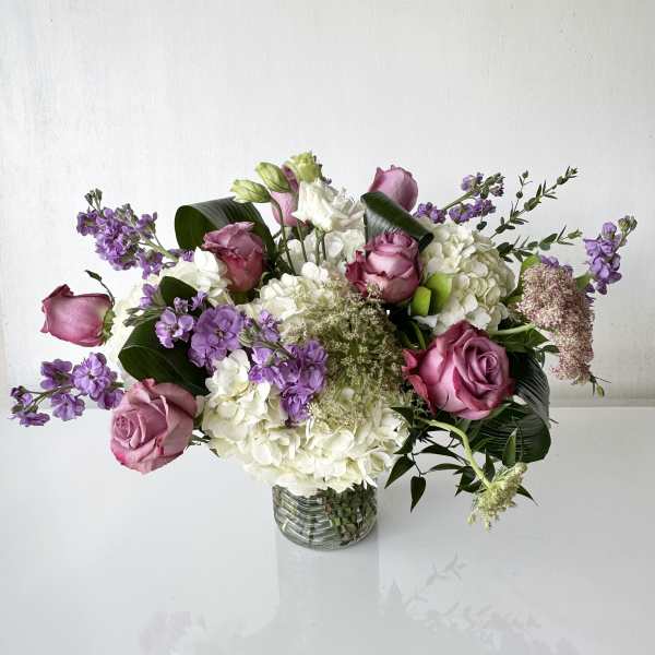 Bouquet of pink roses and white hydrangeas in a clear glass vase