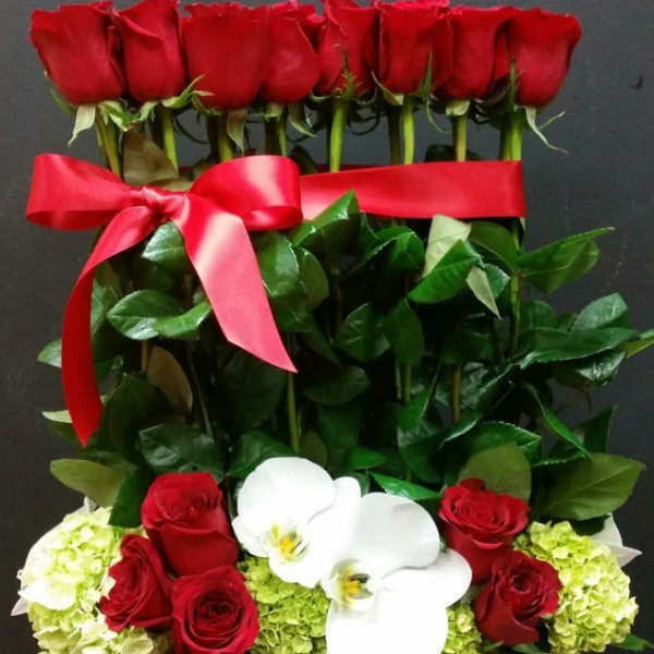 Red roses and white orchids in a gift box with a red ribbon