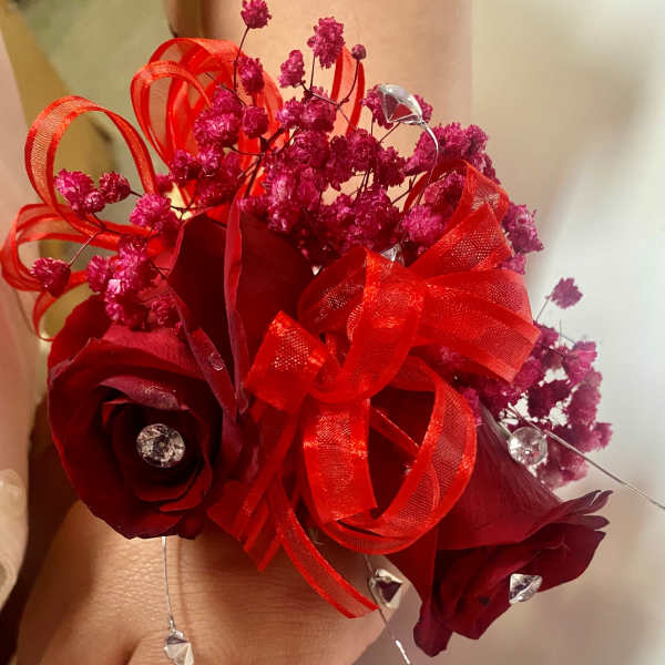 Small red rose bouquet with pink filler and ribbon loops