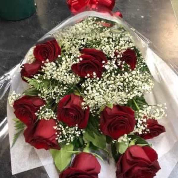 Bouquet of red roses with baby's breath wrapped in white paper