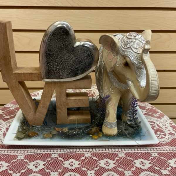 Decorative LOVE sign with a heart and elephant figurine on a tray
