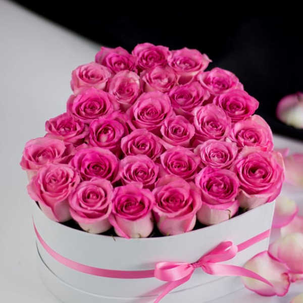 Pink roses arranged in a white hatbox with a pink ribbon
