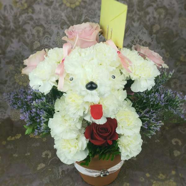 Teddy bear made of white flowers with pink roses and a red rose in a pot