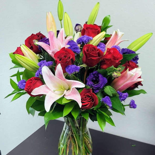 Bouquet of red roses and pink lilies in a glass vase
