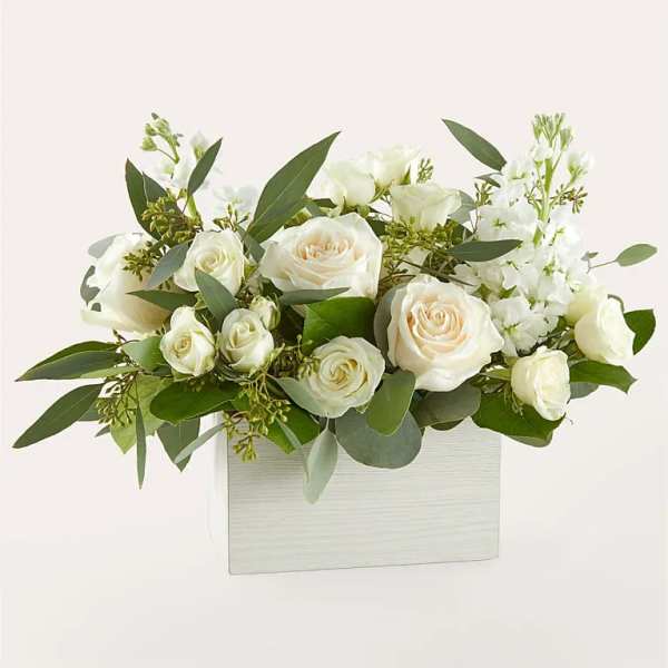 White roses and white blooms arranged in a white box