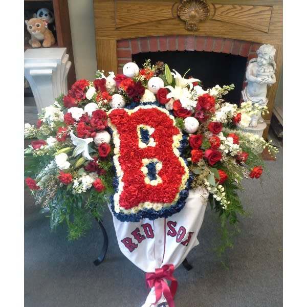 Large floral tribute with a red "B" and Red Sox banner