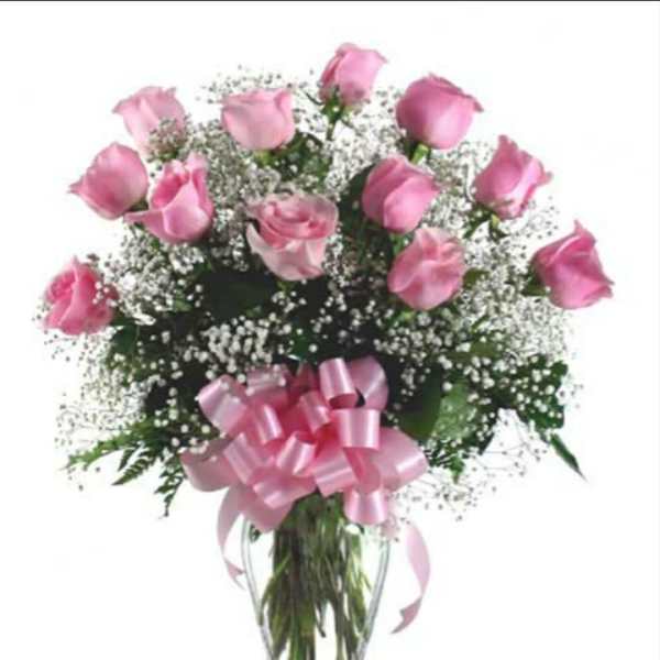 Pink roses in a clear glass vase with a pink ribbon bow