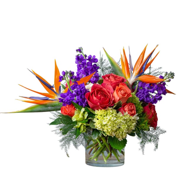 Bouquet of red roses and purple flowers in a clear glass vase