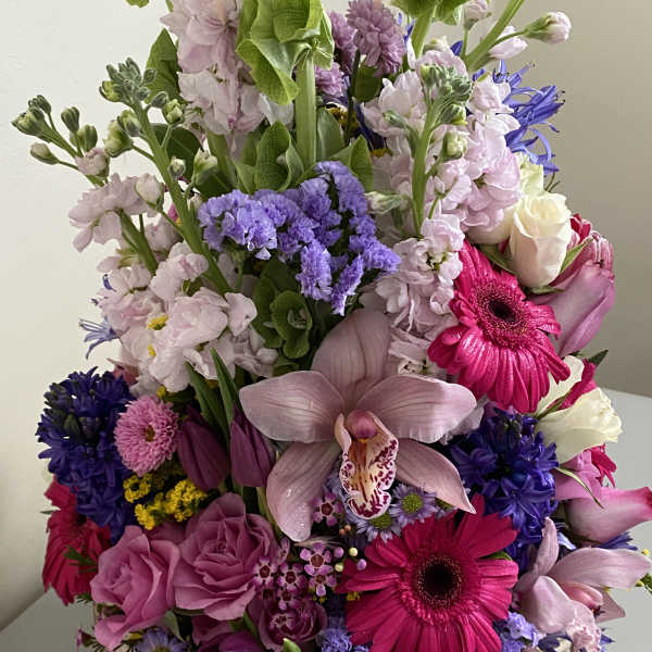 Tall mixed bouquet with pink orchids, gerbera daisies, and purple blooms