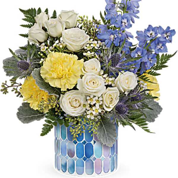 Bouquet of white roses, yellow blooms, and blue flowers in a mosaic vase