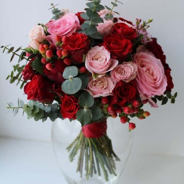 Bouquet of red and pink roses in a clear glass vase